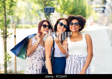 Frauen mit einkaufstaschen unter selfie im Freien Stockfoto