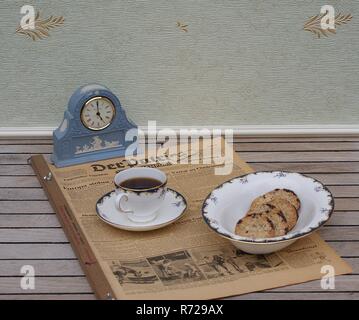 Ein Teil eines englischen Tee vor ein helles Blau Wedgwood Jasperware, Watch Set, mit der angewandten relief Platte mit weißer Tonerde, auf einer alten deutschen Zeitung Stockfoto