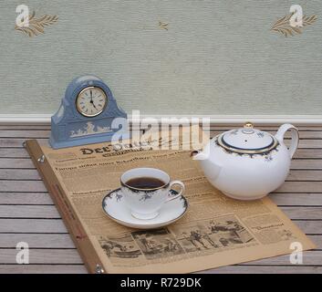 Ein Teil eines englischen Tee vor ein helles Blau Wedgwood Jasperware, Watch Set, mit der angewandten relief Platte mit weißer Tonerde, auf einer alten deutschen Zeitung Stockfoto