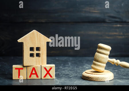 Holz- Haus mit der Aufschrift "Steuer" und "der Richter Hammer. Steuern auf Immobilien, Zahlung. Strafe, Verzug. Register der Steuerzahler für die Eigenschaft. L Stockfoto