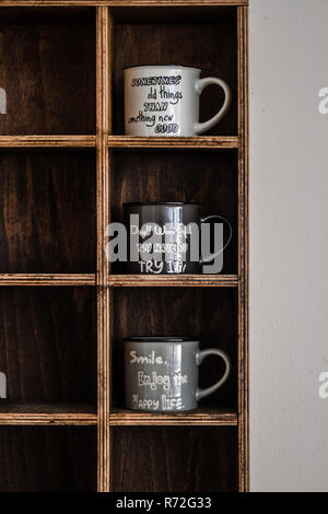 Keramik Kaffeetassen auf handgefertigten Holzmöbeln rustikal Wandregal Stockfoto