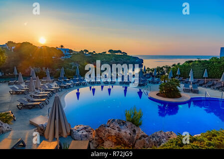 Schönen Sonnenaufgang über Schwimmbad Resort an der Küste der Insel Mallorca, in Cala d'Or, Spanien Stockfoto