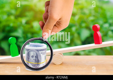 Holzfiguren der Menschen auf der Waage und Dollar zwischen ihnen. ein Streit zwischen zwei Geschäftsleute. Versuch. Umschuldung. Lohn Rückstände. Stockfoto