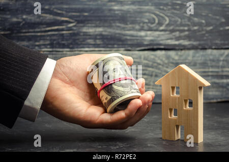 Holz- Haus und Geld in die Hand. Ein Darlehen, die durch Immobilien abgesichert. Home Renovierung und Reparatur. Warme Darlehen. Kauf und Verkauf von Wohnungen. Bezahlbare Wohnungen. T Stockfoto