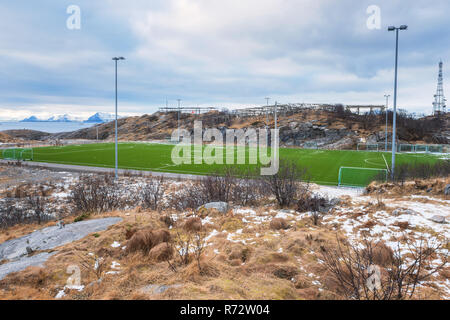 Fußball-Feld auf den Lofoten Inseln, Felsen, Steine und Wasser umgeben, Panoramaaussicht. Sport in Norwegen, Henningsvær, Nordland Stockfoto