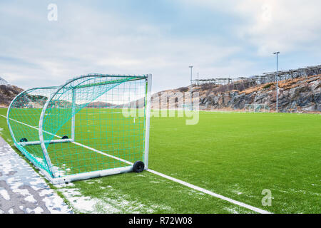 Fußballtor auf dem Fußballfeld auf den Lofoten Inseln, die von Felsen und Steinen umgeben. Sport in Norwegen, Henningsvær, Nordland Stockfoto