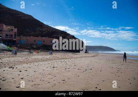 Zu Fuß am Strand entlang mit legzira im Hintergrund. Stockfoto