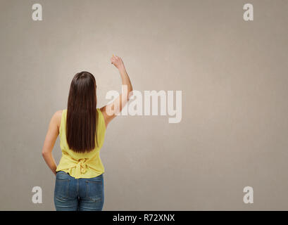 Frau schreiben auf graue Wand Stockfoto