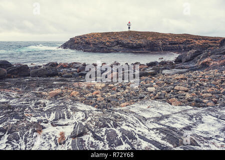 An der felsigen Küste des Atlantischen Ozeans mit Leuchtturm, strenge Winter Landschaft, Lofoten, Norwegen Stockfoto