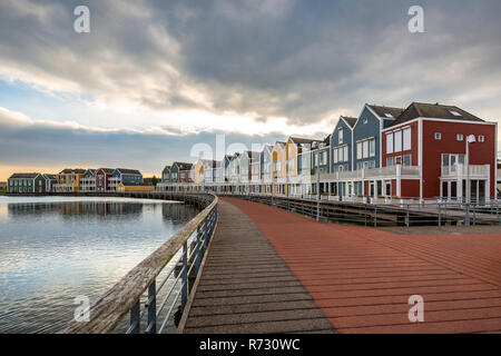 Niederländisch, modernen, farbenfrohen vinex Architektur Häuser am Wasser während der dramatischen und bewölkt, Sonnenuntergang. Houten, Utrecht. Stockfoto