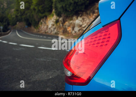 Anreise mit dem Auto. Das Auto geparkt am Straßenrand, vor dem Berg mit Wolken Stockfoto