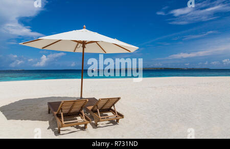 Sonnenschirm und Sonnenliegen am Strand Atoll Insel der Malediven. Stockfoto