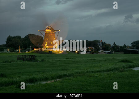 Holländische Windmühle arbeitet und die Lichter an der blauen Stunde beleuchtet. Schönes, typisch holländischen Szene, die in der Nähe des Dorfes Aarlanderveen gefunden werden kann. Stockfoto