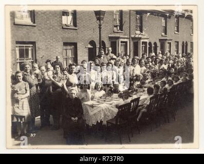Original Postkarte aus der Zeit des 2. Weltkriegs der Postkarte V.E. Tag / Sieg in Europa Tag Tee Street Party Feier, 9. Mai 1945. Es fanden Partys statt, um das Ende des 2. Weltkriegs in Europa zu feiern, unbekannter Ort in einer britischen Straße. Typische Feierlichkeiten zum V.E.-Tag. Erinnerungen an den Krieg. Großbritannien vom 12. Mai 1945. Stockfoto
