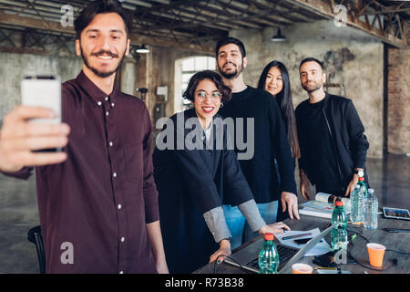 Designer und Kollegen unter selfie am Konferenztisch Stockfoto