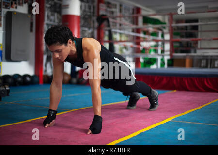 Weibliche boxer Planken tun in der Turnhalle Stockfoto