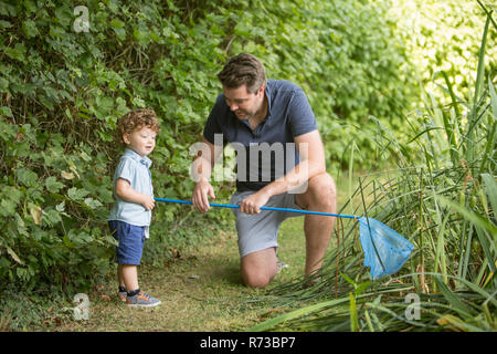 Vater und Kind mit einem Fischernetz in Park Stockfoto