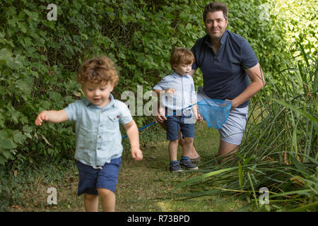 Vater und Kinder mit Fischernetz in Park Stockfoto