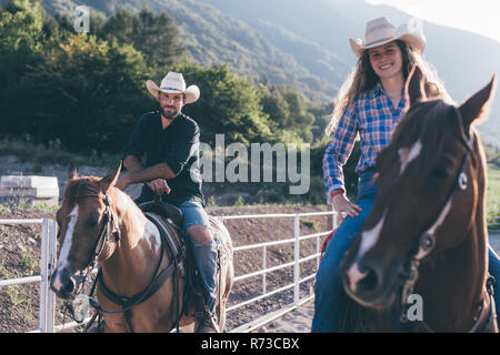 Cowgirl und Jungen zu Pferd im Pferdesport Arena, Porträt, Primaluna, Trentino-Südtirol, Italien Stockfoto