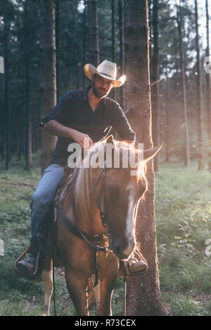 Cowboy zu Pferd im Wald, Porträt, Primaluna, Trentino-Südtirol, Italien Stockfoto