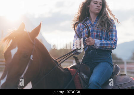 Langhaarige junge Frau auf dem Pferd, Primaluna, Trentino-Südtirol, Italien Stockfoto