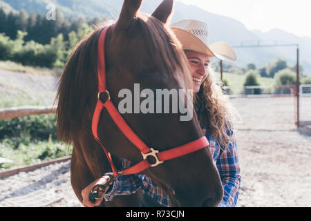 Junge cowgirl führenden Pferd in ländlichen Pferdesport Arena Stockfoto