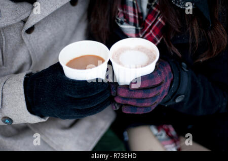 Junges Paar im Winter Handschuhe halten Getränke zum Mitnehmen, in der Nähe der Hände Stockfoto