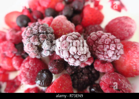 Eine Gruppe von gefrorenen Beeren auf Joghurt. Stockfoto