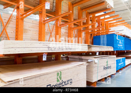 Stapel von Schnittholz und Sperrholz auf große orange Regale an einem Lumberyard. Stockfoto