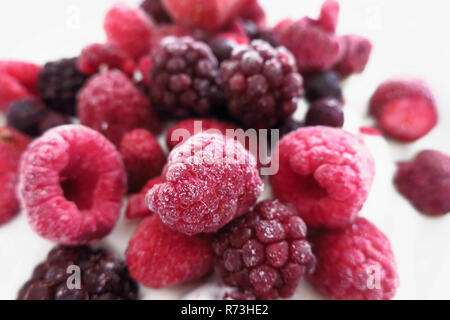 Eine Gruppe von gefrorenen Beeren (Himbeeren, Brombeeren, Blaubeeren und Erdbeeren) auf yoogurt. Stockfoto