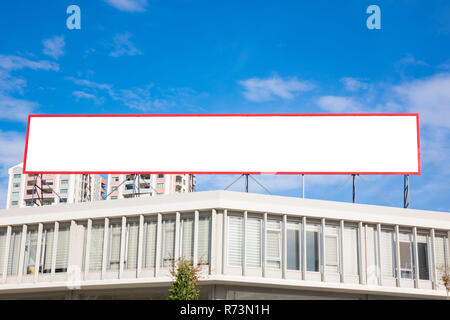 Große leere Plakatwand in Stadt, von Hochhäusern und strahlend blauem Himmel overhead umgeben Stockfoto