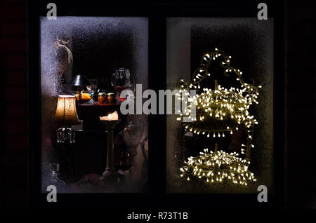 Weihnachten Frosty Fenster mit Kerze, Leuchte, Leuchten, warme und gemütliche Atmosphäre Stockfoto