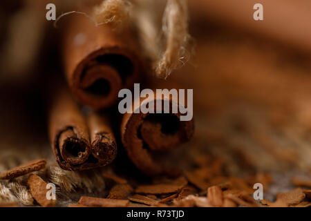 Duftende Zimtstangen und eine Streuung von gemahlen Zimt auf textile unter der Leinwand. Close-up. Stockfoto