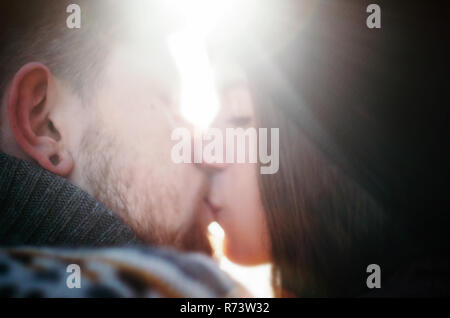 Happy girl kiss Freund mit einem roten Bart gegen Sonnenschein. Glückliche Momente. Close up defokussierten Portrait Stockfoto