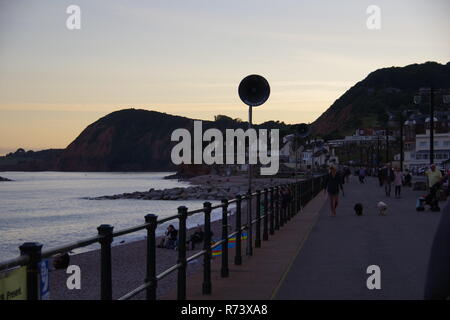 Lautsprecher Silhouette gegen einen subtilen Orange Sommer Himmel bei Dämmerung auf Sidmouth Esplanade. East Devon, Großbritannien. Stockfoto