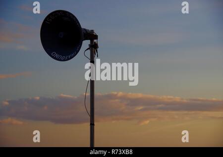 Lautsprecher Silhouette gegen einen subtilen Orange Sommer Himmel bei Dämmerung auf Sidmouth Esplanade. East Devon, Großbritannien. Stockfoto