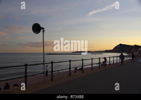 Lautsprecher Silhouette gegen einen subtilen Orange Sommer Himmel bei Dämmerung auf Sidmouth Esplanade. East Devon, Großbritannien. Stockfoto