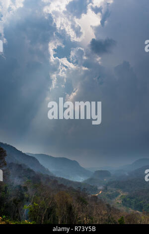 Die Sonne bricht durch die Wolken während des Brennens Saison im Süden Loas, Südostasien. Stockfoto