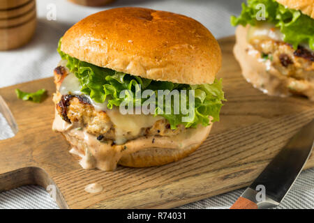 Pikante hausgemachte Chipotle Chicken Burger mit Salat Stockfoto