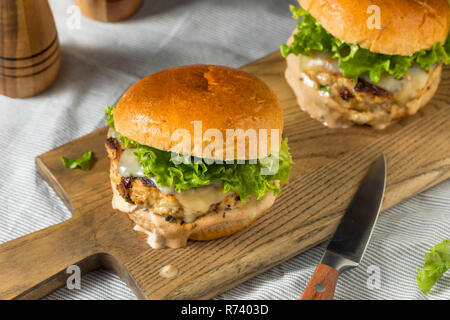 Pikante hausgemachte Chipotle Chicken Burger mit Salat Stockfoto