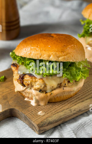 Pikante hausgemachte Chipotle Chicken Burger mit Salat Stockfoto