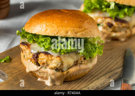 Pikante hausgemachte Chipotle Chicken Burger mit Salat Stockfoto