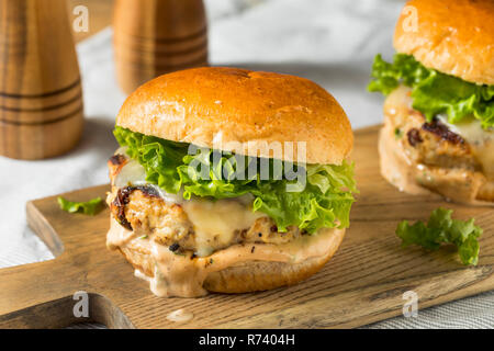 Pikante hausgemachte Chipotle Chicken Burger mit Salat Stockfoto