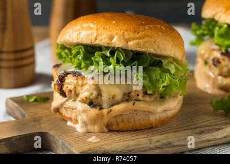 Pikante hausgemachte Chipotle Chicken Burger mit Salat Stockfoto