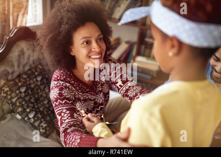 Happy afrikanischen Familie - Mutter und Tochter zusammen spielen für die Weihnachtsfeiertage Stockfoto