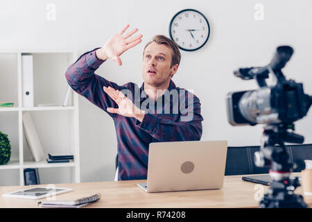 Männliche video blogger Aufnahme vlog schockiert und von sich aus etwas im Büro Stockfoto