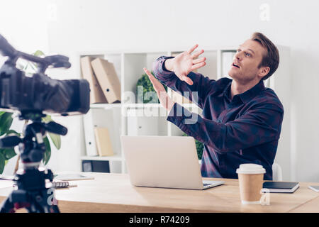 Männliche video blogger Aufnahme vlog und STOP-Schild im Amt schockiert Stockfoto