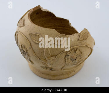 Fragment steinzeug Krug mit geprägtem Rosen und Blumen, Kanne, Geschirr halter Boden Keramik Steinzeug Salz Glasur Glasur finden, Hand gestempelt glasiert Glasierte gebackene Steingut Kanne auf Standfläche mit Spuren von Abzug. Grau glasiert. Kugelförmigen Modell auf dem Bauch schwingen rose Zweige und Blumen in der Entlastung angewendet. Einige Profil Ring über dem Fuß Archäologie Grube Rotterdam Stadscentrum Stadsdriehoek Groenendaal befindet sich ausländische Keramik Import trinken Tisch Boden Entdeckung spenden: Grube Groenendaal befindet sich aus großen Abfall Grube 1977.06.10. Stockfoto