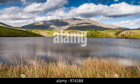 Snowdon Mountain steigt von der Küste von Llyn y Dywarchen, einem kleinen See ar Rhyd-Ddu im Snowdonia National Park, North Wales. Stockfoto