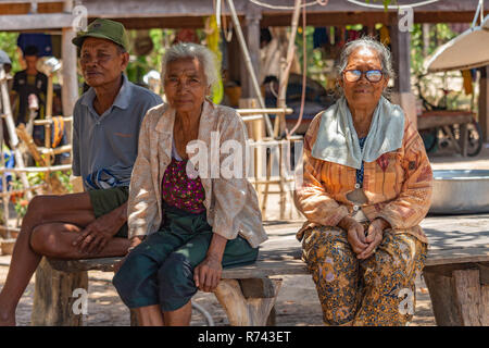 Don Daeng, Laos - 27. April 2018: die Gruppe der älteren Dorfbewohner sitzt auf einer Holzbank, Stockfoto